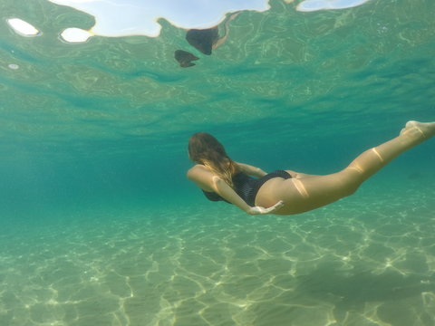 Chica buceando en mar de aguas cristalinas