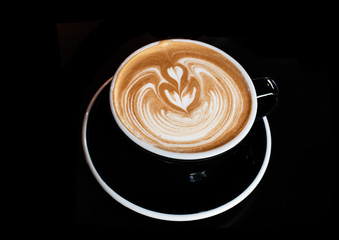 The cappuccino in black ceramic cup,on black table