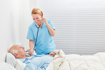 Ärztin mit Stethoskop untersucht Patient