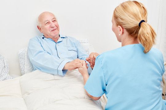 Krankenschwester hält Hände von einem Senior