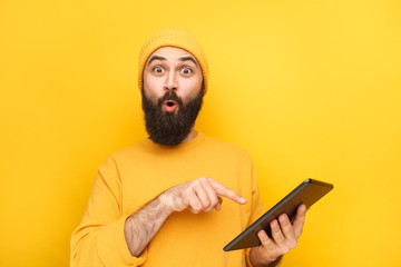 Expressive guy pointing at tablet