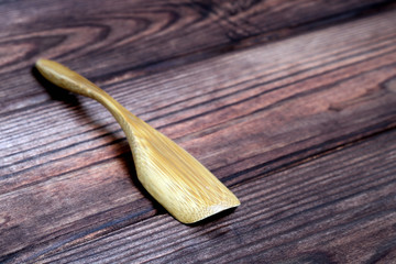 Small wooden spoon in the kitchen on a wooden background