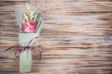 Ranunculus, leafs, twigs on wood