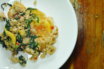 fried egg topping spicy minced pork with basil leaf on plate
