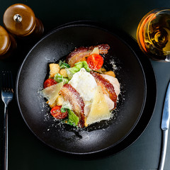 Delicious Ceasar salad with tomatoes, bacon poached egg