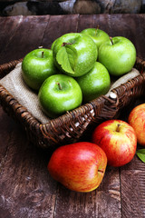 Ripe red apples and green apple on wooden background