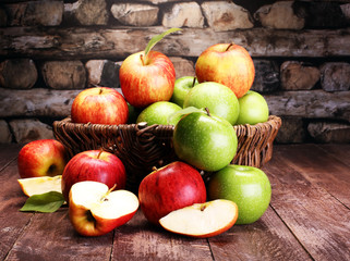 Ripe red apples and green apple on wooden background