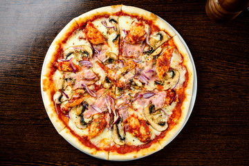 Tasty warm pizza with bacon, mushrooms, cheese and onions on the