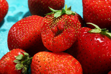 Heap of fresh strawberries on blue background