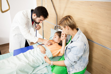 Naklejka na ściany i meble Doctor checking her patient heart in hospital 