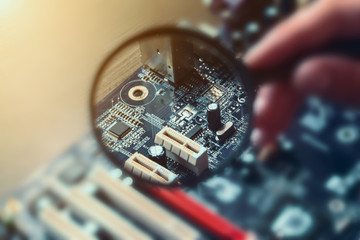 motherboard through a magnifying glass. Blurred computer background