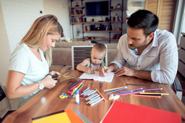 Mom dad and son draw in the living room