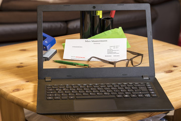 brief mit büromaterial und Brille auf laptop