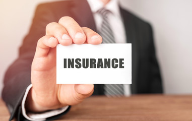 Businessman holding a card with text Insurance