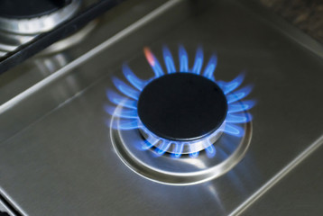 Burning gas, gas stove burner, hob in the kitchen. Blue gas stove in the dark