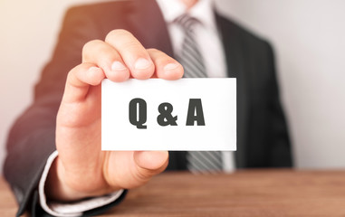 Businessman holding a card with text Q and A