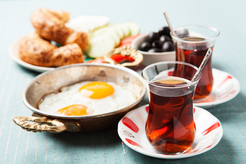 Traditional Turkish breakfast with fried eggs and tea