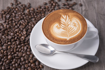 latte or Cappuccino with frothy foam, coffee cup top view on table in cafe.