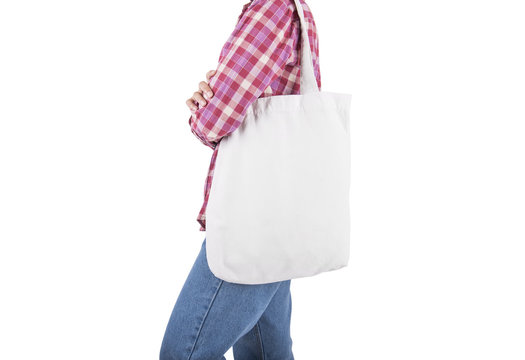 Girl is holding bag canvas fabric for mockup blank template isolated on white background.