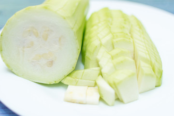 Cut zucchini on a white plate.