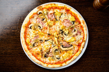 Tasty warm pizza with bacon, mushrooms, cheese and onions on the