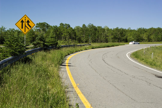 Traffic merge sign beside rural highway