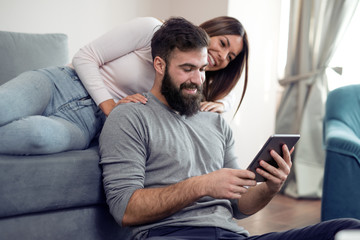 Young couple at home surfing on tablet