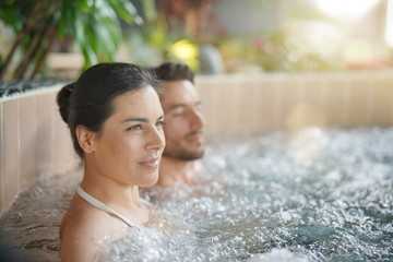 Couple relaxing in spa resort hot pool