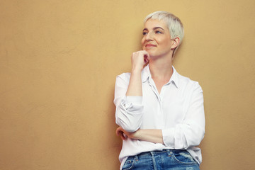 blonde junge Frau steht an der Wand