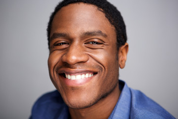 Obraz premium Close up happy african man smiling against gray background
