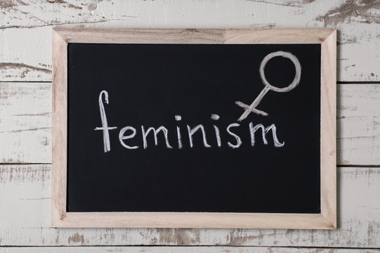 The word "feminism" and venus symbol at blackboard, top view