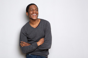 confident african american man smiling with arms crossed against white background