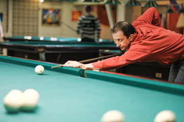 the player takes aim at the ball in Billiards