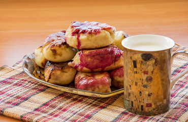 hot pie with berries, fried in oil, lined in a dish, a mug of cold milk with Klimt 