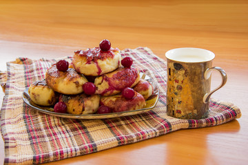 hot pie with berries, fried in oil, lined in a dish, a mug of cold milk with Klimt 