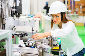 beautiful pretty components milling machine factory female staff holding pliers processing parts.