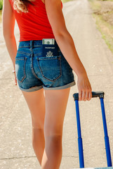 Sexy woman's back in jean shorts with a passport and money in a pocket on the back.