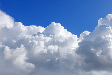 Naklejka na ściany i meble Beautiful, white cumulus clouds against the blue sky on a sunny day.