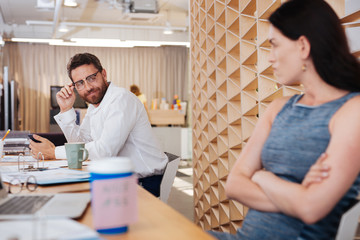 Sexual harassment. Lustful bearded man smiling and looking at his colleague
