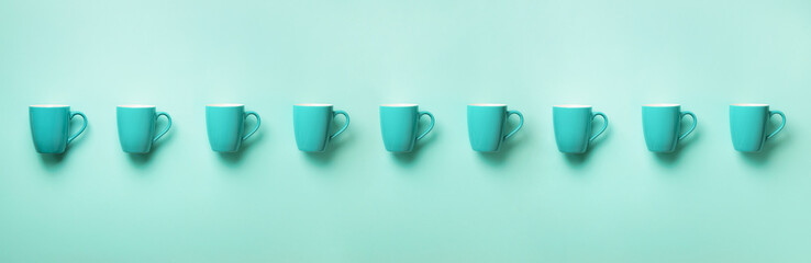 Pattern from blue cups over blue background. Banner. Birthday party celebration, baby shower concept. Punchy pastel colors. Minimalist style design