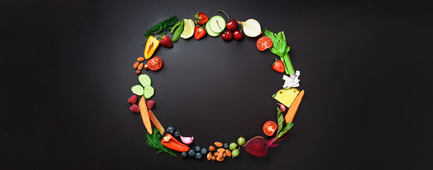 Healthy food background. Circle of organic vegetables, fruits, nuts, berries with copy space on black chalkboard. Top view. Vegetarian, vegan, detox and clean eating concept