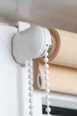 Beige blackout roller blind on the white plastic window. Shutters on the plastic window.