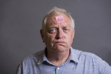 Obraz premium Tired and stressed mature man on a grey background 