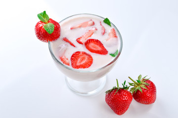 Homemade yogurt with fresh red strawberry on a wooden background. Top view.