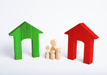 A family with children stand between two houses and make a decision, they make a choice. Adoption of the right decision and priority, the designation of the future family. The search for a new home.