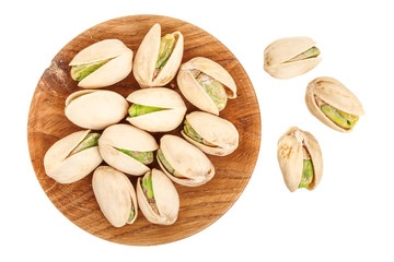 Pistachios in wooden bowl isolated on white background, top view. Flat lay