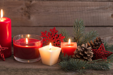 Christmas decoration with red candles on wooden background