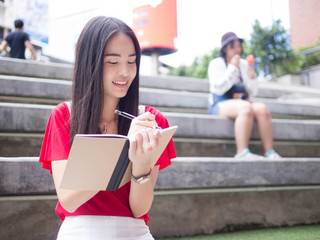 Young Asian female student with notebooks in her hands.A portrait of an Asian college student.education and learning concept.