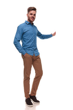 relaxed casual man standing and presenting behind