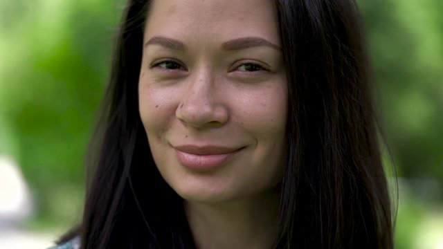 A portrait of a cute asian woman blinking with her eyes. Close-up.